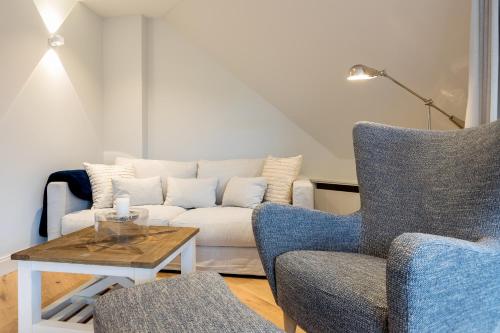 a living room with a couch and two chairs at Wattjuwel ehem Wattperle in Munkmarsch