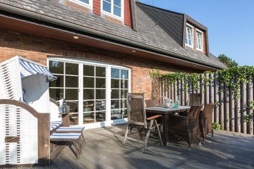 a patio with a table and chairs on a deck at Heide Hues in Munkmarsch