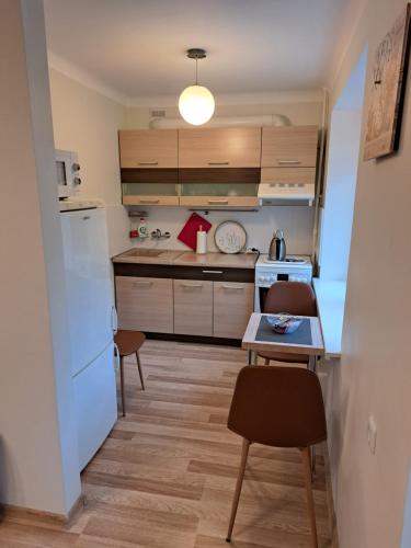 a kitchen with a white refrigerator and a table at Sweet home in Šiauliai