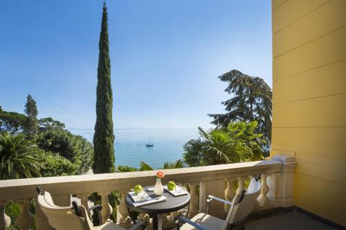 einen Balkon mit einem Tisch, Stühlen und Meerblick in der Unterkunft Villa Amalia - Liburnia in Opatija