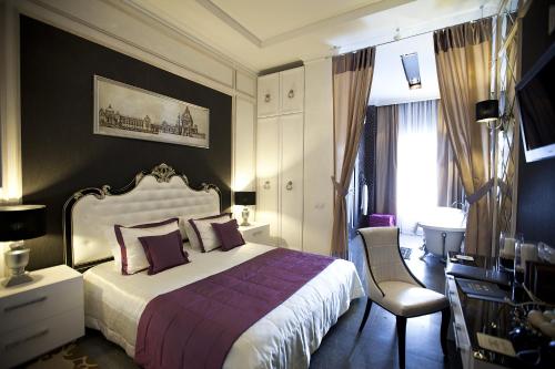 a bedroom with a bed and a desk and a chair at Mirax Boutique Hotel in Kharkiv