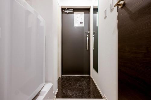 a bathroom with a walk in shower with a door at FL Residence Jingu Gyoen IV in Tokyo