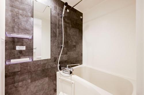 a bathroom with a shower and a toilet and a mirror at FL Residence Jingu Gyoen IV in Tokyo