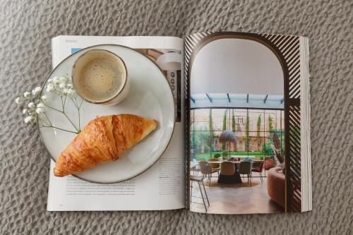 a book with a plate of pastry and a cup of coffee at Maison Lùisa in Autun