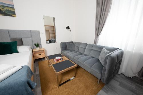 a living room with a couch and a table at Penzion MOVEINN in Prague