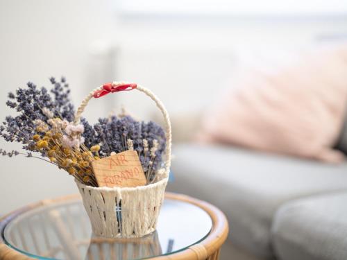 a basket of flowers sitting on a glass table at AIR FURANO in Furano