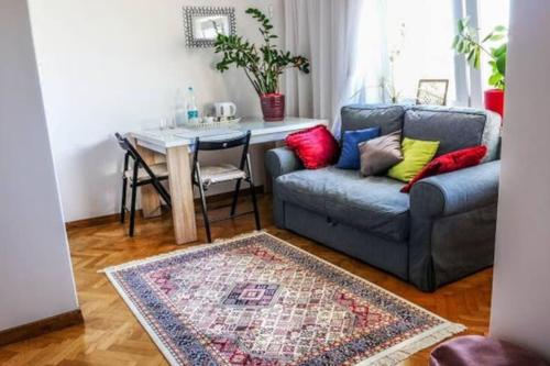 uma sala de estar com um sofá e uma mesa em A cosy private room in the heart of old Podgorze em Cracóvia
