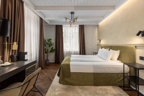 a hotel room with a bed and a desk at Konventa Sēta Hotel Keystone Collection in Rīga