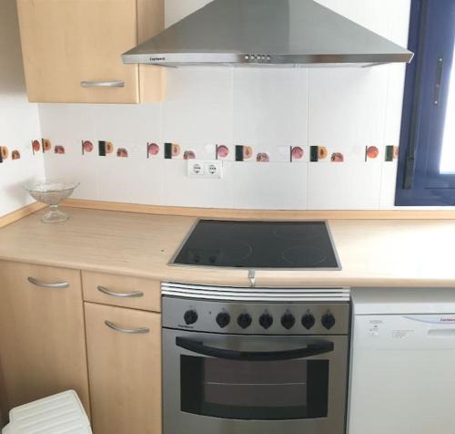 a kitchen with a stove and a microwave at Apt Mar de Pujols 2 - FormenteraLodge in Es Pujols