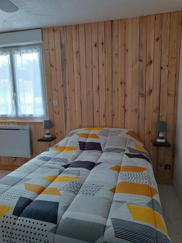 - un grand lit dans une chambre dotée de murs en bois dans l'établissement Appartement cosy en résidence, avec parking, à Saint-Hilaire-de-Riez