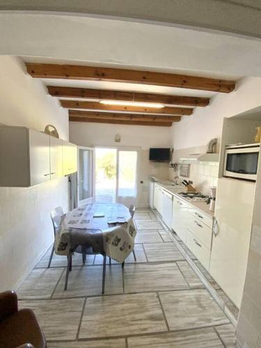 une cuisine avec une table au milieu dans l'établissement Appartement en rez de villa, à Aregno