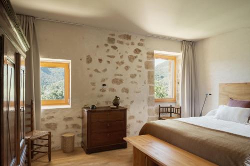 a bedroom with a bed and two windows at El Priorato de Trespaderne in Trespaderne