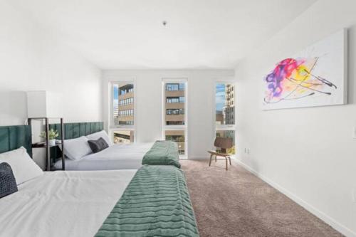 a bedroom with two beds and a painting on the wall at Downtown Santa Monica Top Floor Ocean View 2BR/2BA in Los Angeles