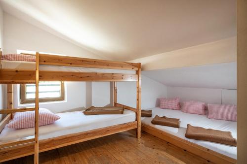 two bunk beds in a room with wooden floors at Berggasthof Rofan in Maurach