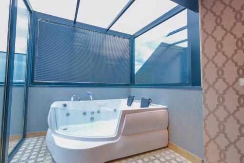 a bath tub in a bathroom with windows at Silver Inn Hotel & Spa in Kasaplar