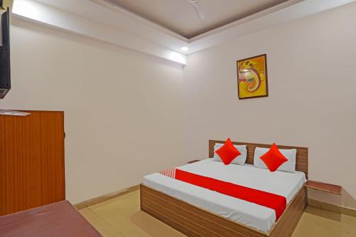1 dormitorio con 1 cama con almohadas rojas en OYO Flagship Mohan Residency, en Indirapuram