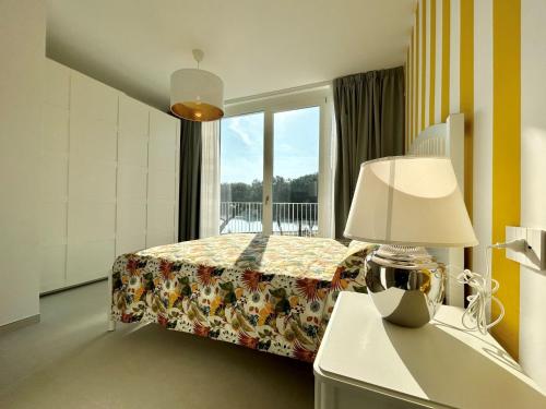 een slaapkamer met een bed met een lamp en een raam bij Stunning villa with pool and lagoon view in Palazzo Vianello