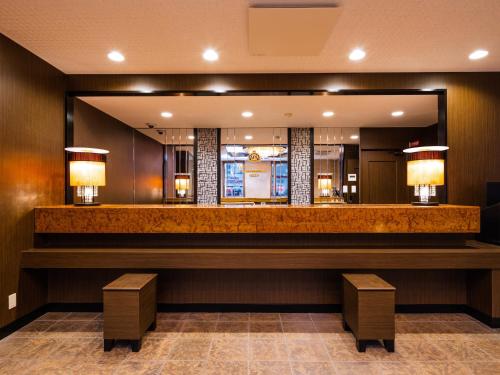 a bar in a hotel lobby with a mirror at APA Hotel Akita Senshu Koen in Akita