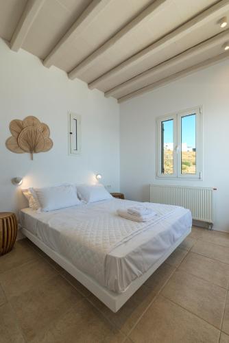a white bedroom with a large bed in a room at La Chapelle Est in Agios Romanos