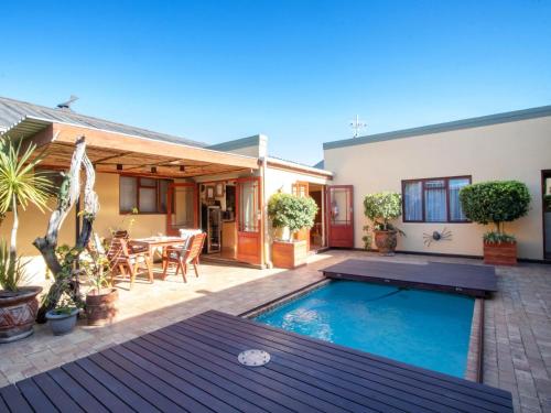 a backyard with a swimming pool and a house at Dai Heka Guest House in Strand