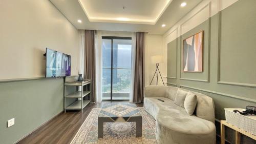 a living room with a couch and a tv at Căn Hộ Cao Cấp 2 Ngủ Grand Tower in Hai Phong