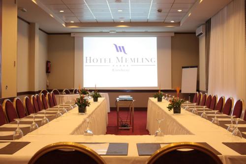 a meeting room with a projector screen and tables at Hotel Memling in Kinshasa