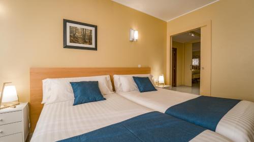 una camera da letto con un grande letto con cuscini blu di Apartaments Del Meligar a Encamp