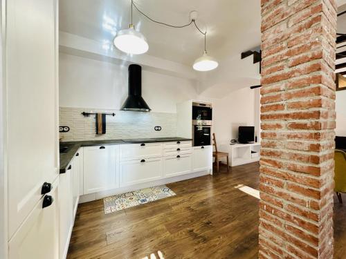 eine Küche mit weißen Schränken und einer Ziegelwand in der Unterkunft Agudes CostaBravaSi in Santa Cristina d'Aro