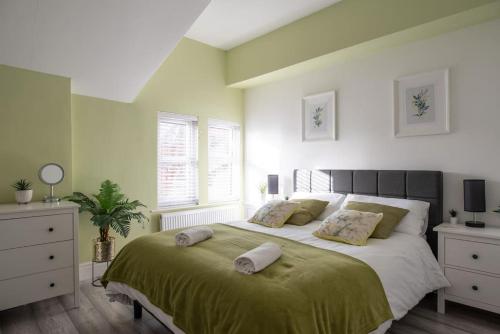 a bedroom with a large bed with two pillows on it at 8 Bed, comfortably sleeps 10, 3 Bath house, 5 Mins Manchester Centre in Manchester