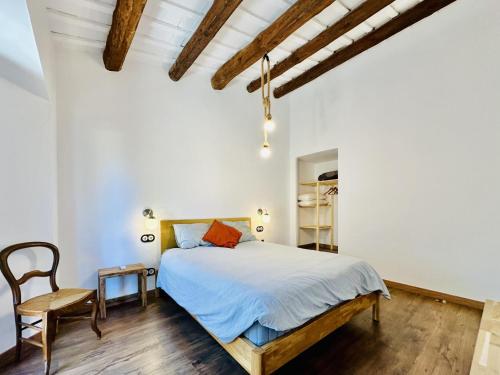 ein Schlafzimmer mit einem Bett und einem Stuhl in der Unterkunft Agudes CostaBravaSi in Santa Cristina d'Aro
