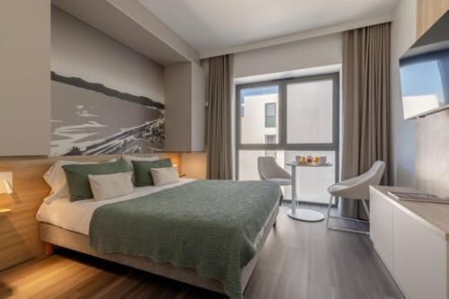 a bedroom with a large bed and a television at Lagrange Apart'Hôtel Antibes Olympie in Antibes
