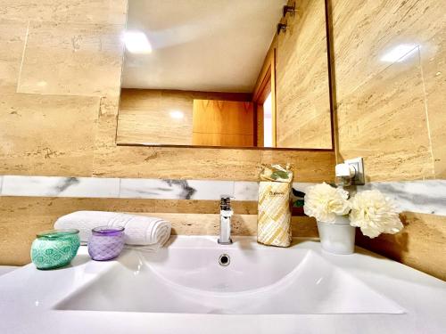 a white sink in a bathroom with a mirror at Alkadir Home in Villajoyosa