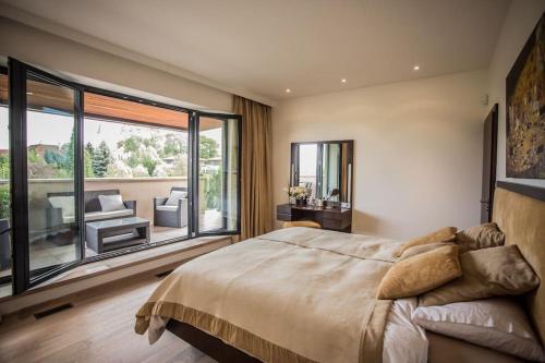 a bedroom with a large bed and a large window at Luxury villa near Prague with pool and tennis court in Čestlice