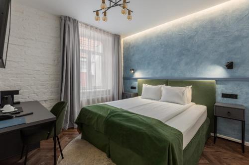 a hotel room with a bed and a desk and a bed at Konventa Sēta Hotel Keystone Collection in Rīga