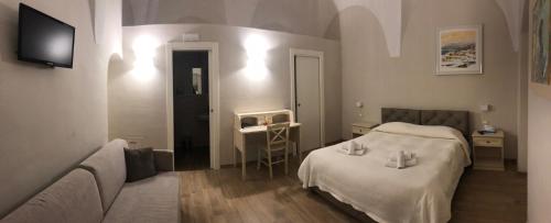 1 dormitorio con cama, sofá y TV en Residenza la Portella, en Bovino