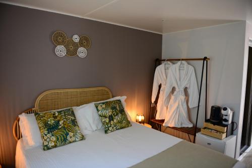 ein Schlafzimmer mit einem Bett und einem an der Wand hängenden Kleid in der Unterkunft Camping Casa Di Caccia in Marina di Bibbona