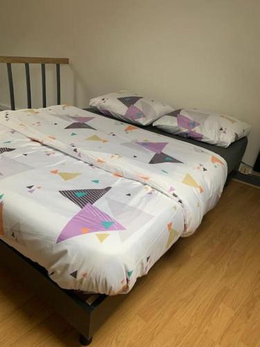 - un lit avec une couette dans l'établissement Maison proche centre-ville 4 personnes 2 chambres, à Amiens