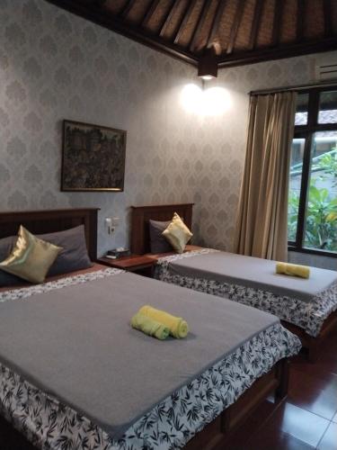 two beds sitting next to each other in a bedroom at Dewa Bungalows in Ubud