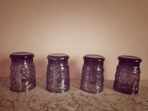 a group of four glass jars sitting on a counter at B&B Lieven Bauwens in Ghent