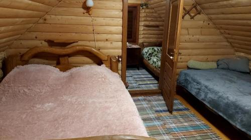 1 dormitorio con 2 camas en una cabaña de madera en У Медовому Раю, en Rostoka