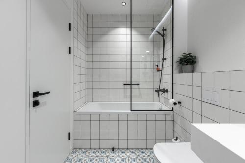 a bathroom with a shower with a tub and a sink at Konventa Sēta Hotel Keystone Collection in Rīga