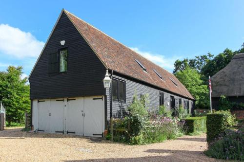 a black barn with a white garage at Duckpitts Barn in Canterbury