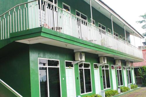 un edificio verde con balcón en la parte superior. en Hotel Antik, en Soreang