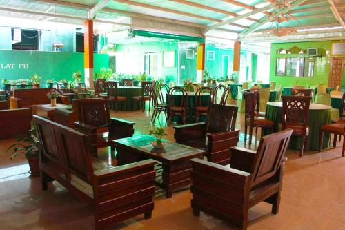 ein Restaurant mit Tischen und Stühlen in einem Zimmer in der Unterkunft Hotel Antik in Soreang
