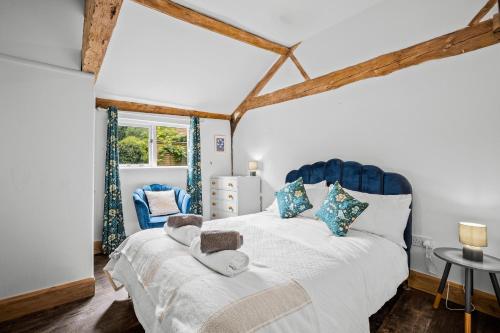 a bedroom with a large bed with a blue headboard at Long Barn in Little Marcle