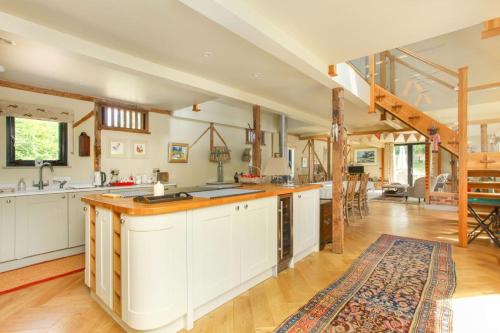 an open kitchen with white cabinets and a kitchen island at Duckpitts Barn in Canterbury