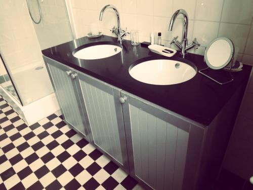 a bathroom with two sinks and two mirrors at B&B Lieven Bauwens in Ghent