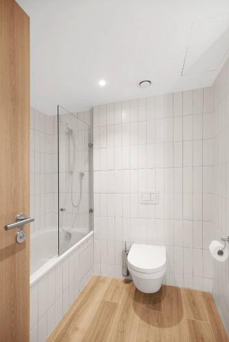 a bathroom with a toilet and a tub and a shower at Hilton Garden Inn Bucharest Airport in Otopeni