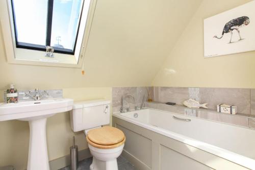 a bathroom with a toilet and a sink and a bath tub at Duckpitts Barn in Canterbury