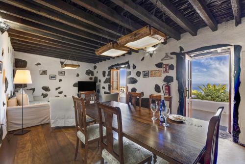 a dining room with a wooden table and chairs at El Lagar in Frontera